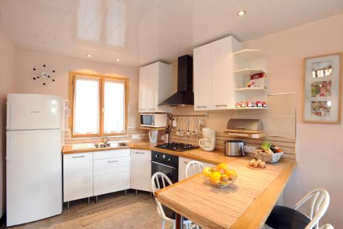 una cucina con mobili bianchi e un tavolo con una fruttiera di Pavillon de Diane a Prades