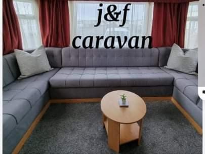 ein Wohnzimmer mit einem Sofa und einem Tisch in der Unterkunft J & F caravan in Skegness