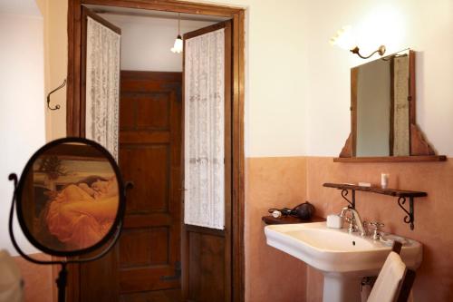 a bathroom with a mirror and a sink at Antico Borgo Sanda Lago Maggiore in Casalzuigno