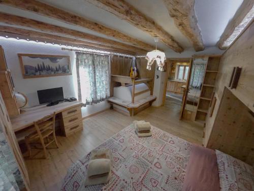 a bedroom with a bed and a desk and a television at Casa Soraya in Falcade