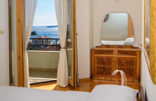 a bedroom with a mirror and a bed and a window at Villa Nerium in Seget Vranjica
