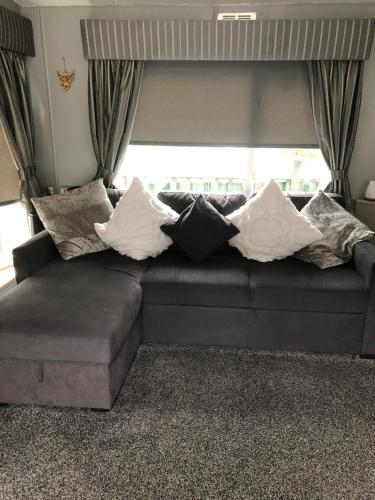 ein Sofa mit Kissen darauf im Wohnzimmer in der Unterkunft 4 Squirrel View in Stranraer