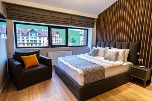 a bedroom with a large bed and a chair at 3-Bedroom Luxury Apartment in New Gudauri in Gudauri