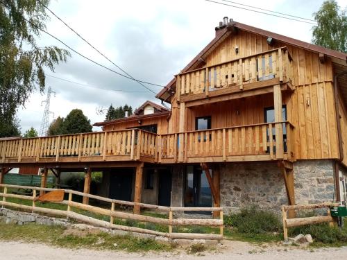 une maison en bois entourée d'une terrasse. dans l'établissement Au grenier du lac, à Gérardmer