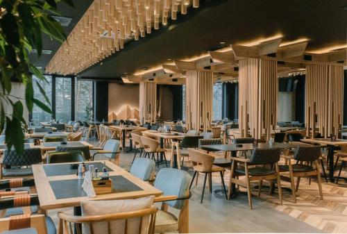 HOTEL ROYAL MOUNTAIN في ديفشيبار: مطعم به طاولات وكراسي ونوافذ كثيرة