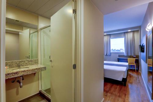 a hotel room with a bed and a bathroom at Transamerica FIT Lucas do Rio Verde in Lucas do Rio Verde