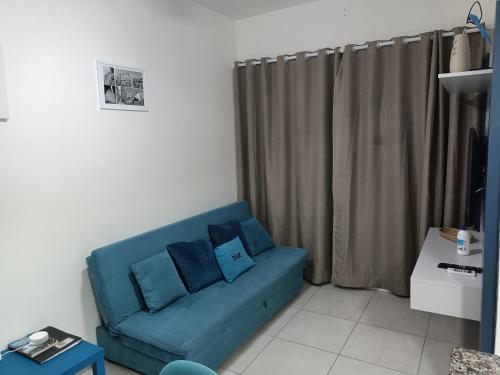 ein blaues Sofa mit Kissen im Wohnzimmer in der Unterkunft Blue Ubatuba in Ubatuba