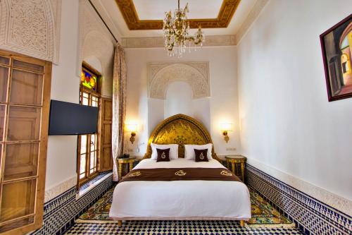a bedroom with a bed and a chandelier at Riad Marjana suites & Spa in Fez