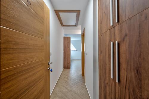a hallway with wooden doors and a hallway leading to a bedroom at Lovac apartmani in Zlatibor