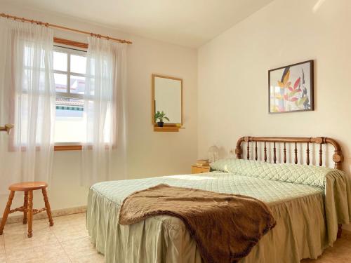 AbadesにあるChalet con terraza soleadaのベッドルーム1室(ベッド1台、窓、スツール付)