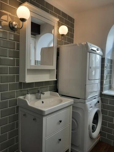 a bathroom with a sink and a washing machine at NewOne Apartman in Sopron