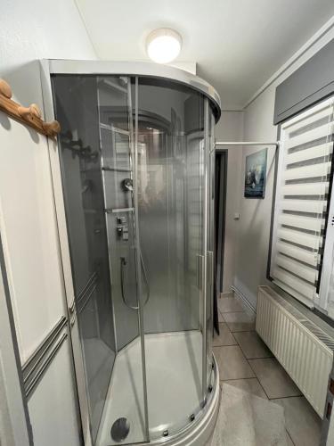 une douche avec une porte vitrée dans une salle de bain dans l'établissement Bel Appartement 4 personnes bien placé, à Boulogne-sur-Mer