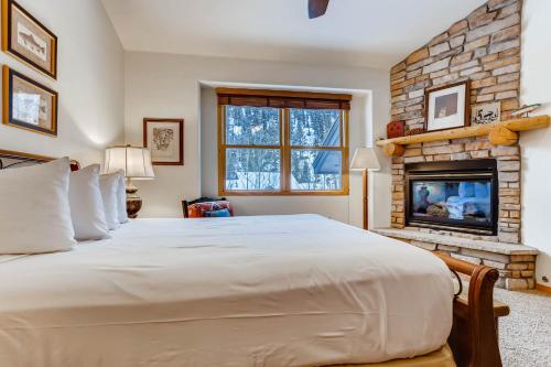 a bedroom with a large bed and a fireplace at Premiere 2Br Townhome - Shuttle to Slopes, Kids Ski Free! condo in Keystone