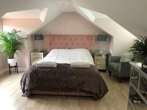 a bedroom with a large bed with a pink headboard at HAYFIELD COTTAGE spacious detached luxury home in Copmanthorpe