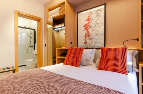 a bedroom with a bed with orange pillows on it at Rossio Plaza Hotel in Lisbon