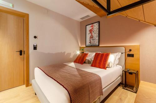 a bedroom with a bed with orange and white pillows at Rossio Plaza Hotel in Lisbon
