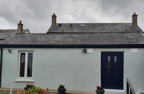 a white house with a blue door at 17A DB Airbnb in Wexford