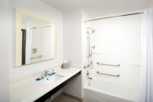 a white bathroom with a sink and a shower at Holiday Inn Express & Suites - North Brunswick by IHG in North Brunswick