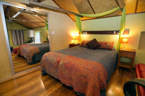 a hotel room with a bed and a mirror at Witches Falls Cottages in Mount Tamborine