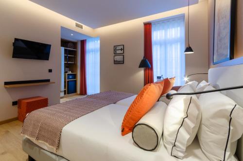 a bedroom with a large white bed with orange pillows at Rossio Plaza Hotel in Lisbon