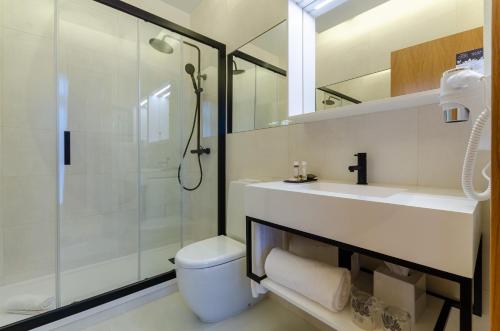 a bathroom with a shower and a toilet and a sink at Rossio Plaza Hotel in Lisbon