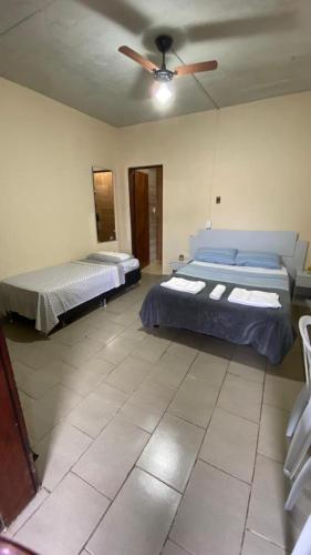 a bedroom with two beds and a ceiling fan at Pousada TRUFFIMAR Ilhabela in Ilhabela