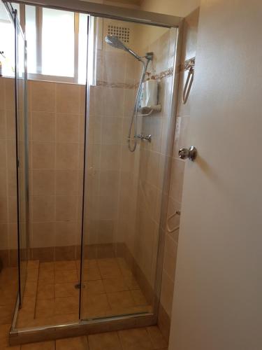 een douchecabine met een glazen deur in de badkamer bij Waterfront Location - 2 Bed Apartment in Corlette, Port Stephens - Sleeps 4 in Corlette