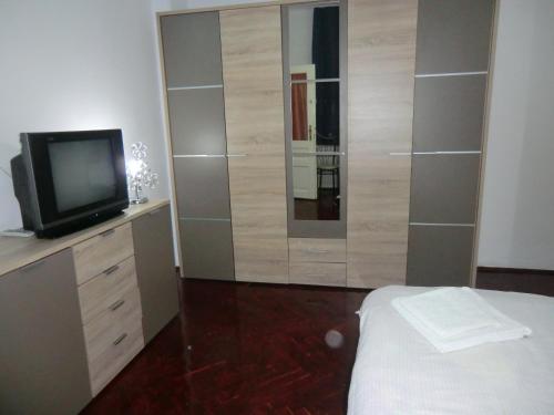 a bedroom with a television and a dresser with a bed at Pension Casa Samurai in Braşov
