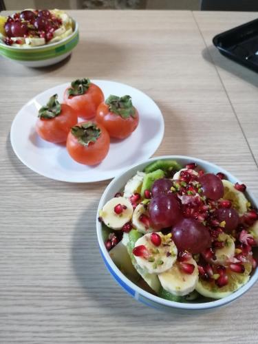 two plates of food with tomatoes and a bowl of fruit at Antichi Quartieri in Piazza Armerina
