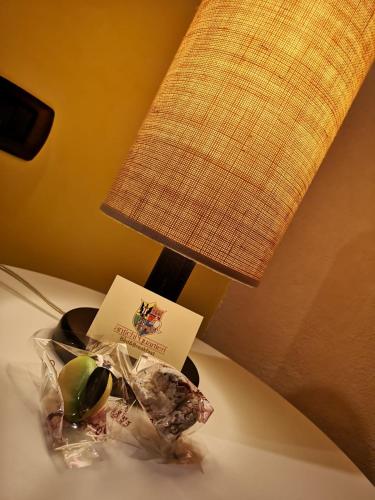 a table with a lamp and a plate of food at Antichi Quartieri in Piazza Armerina