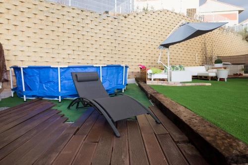 a wooden deck with a chair and an umbrella at Finca Olivar de Castilla - Sun&Colors in Segovia