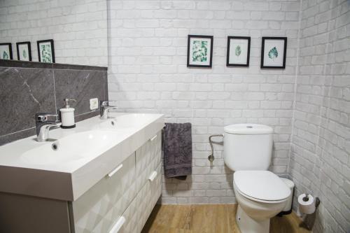 a white bathroom with a toilet and a sink at La Laguna Treasure: exclusiveness prime location in La Laguna