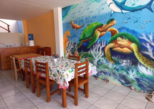 a dining room with a mermaid mural on the wall at HOSTAL JANET STARLiNK in Puerto Villamil