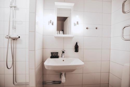 a white bathroom with a sink and a shower at Siljansnäs Hotell in Siljansnäs