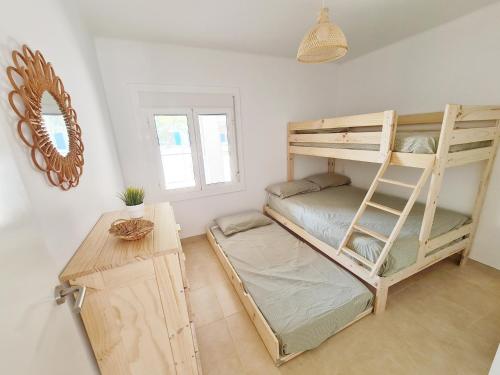 1 dormitorio con 2 literas y mesa en Can Xiquets, en Riumar