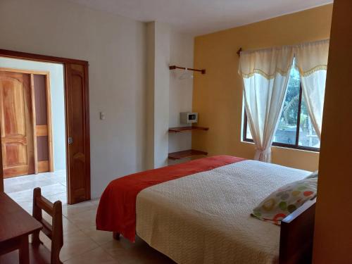 ein Schlafzimmer mit einem großen Bett und einem Fenster in der Unterkunft HOSTAL JANET STARLiNK in Puerto Villamil
