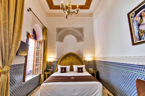 a bedroom with a bed and a chandelier at Riad Marjana suites & Spa in Fez