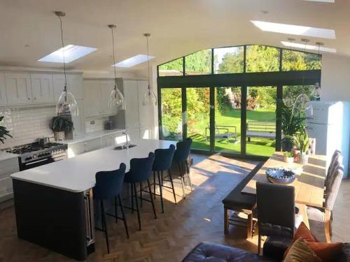 a kitchen with a large white island in a kitchen with chairs at HAYFIELD COTTAGE spacious detached luxury home in Copmanthorpe