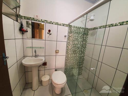 La salle de bains est pourvue de toilettes, d'un lavabo et d'une douche. dans l'établissement Pousada do Beto, à Ubatuba