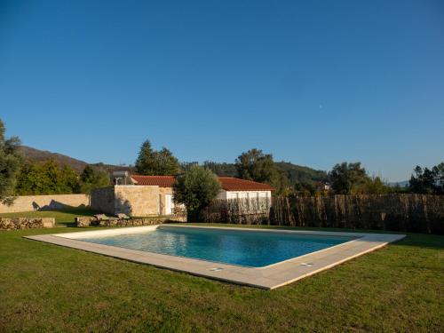 a swimming pool in the middle of a yard at Casa da Portelinha in Arcos de Valdevez