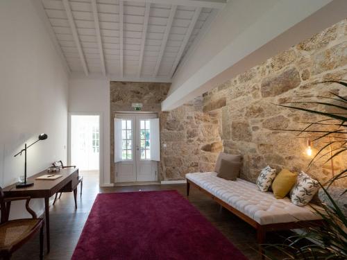 a living room with a stone wall at Casa da Portelinha in Arcos de Valdevez