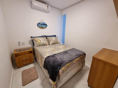 a small bedroom with a bed and a desk at Apartamento Angra dos Reis 2 novo in Angra dos Reis