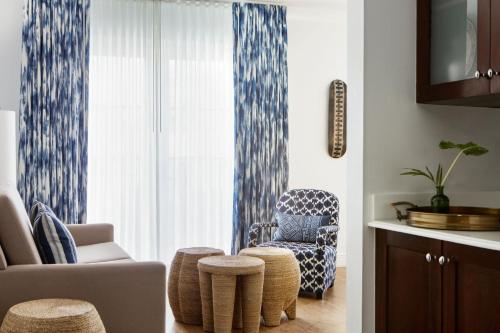 a living room with a chair and ottoman at Kimpton Angler’s Hotel South Beach by IHG in Miami Beach