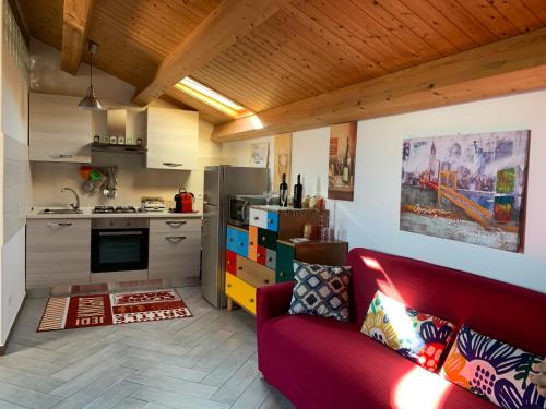 un soggiorno con divano rosso e una cucina di Casa Alcalà Deluxe a Catania