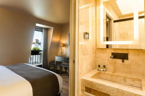 a hotel room with a bed and a bath tub at B Montmartre in Paris