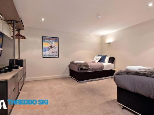 a bedroom with two beds and a television in it at The Peak 5 in Thredbo