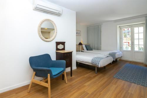 a bedroom with a bed and a chair and a mirror at Historical Center - Taipas Apartments in Porto