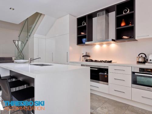 a kitchen with white cabinets and a white counter top at The Peak Penthouse 9 in Thredbo