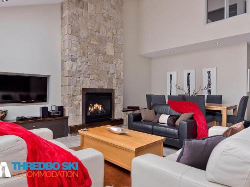 a living room with couches and a fireplace at The Peak Penthouse 9 in Thredbo