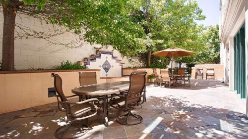 a table and chairs and an umbrella on a patio at Best Western Inn & Suites San Mateo - San Francisco Airport in San Mateo